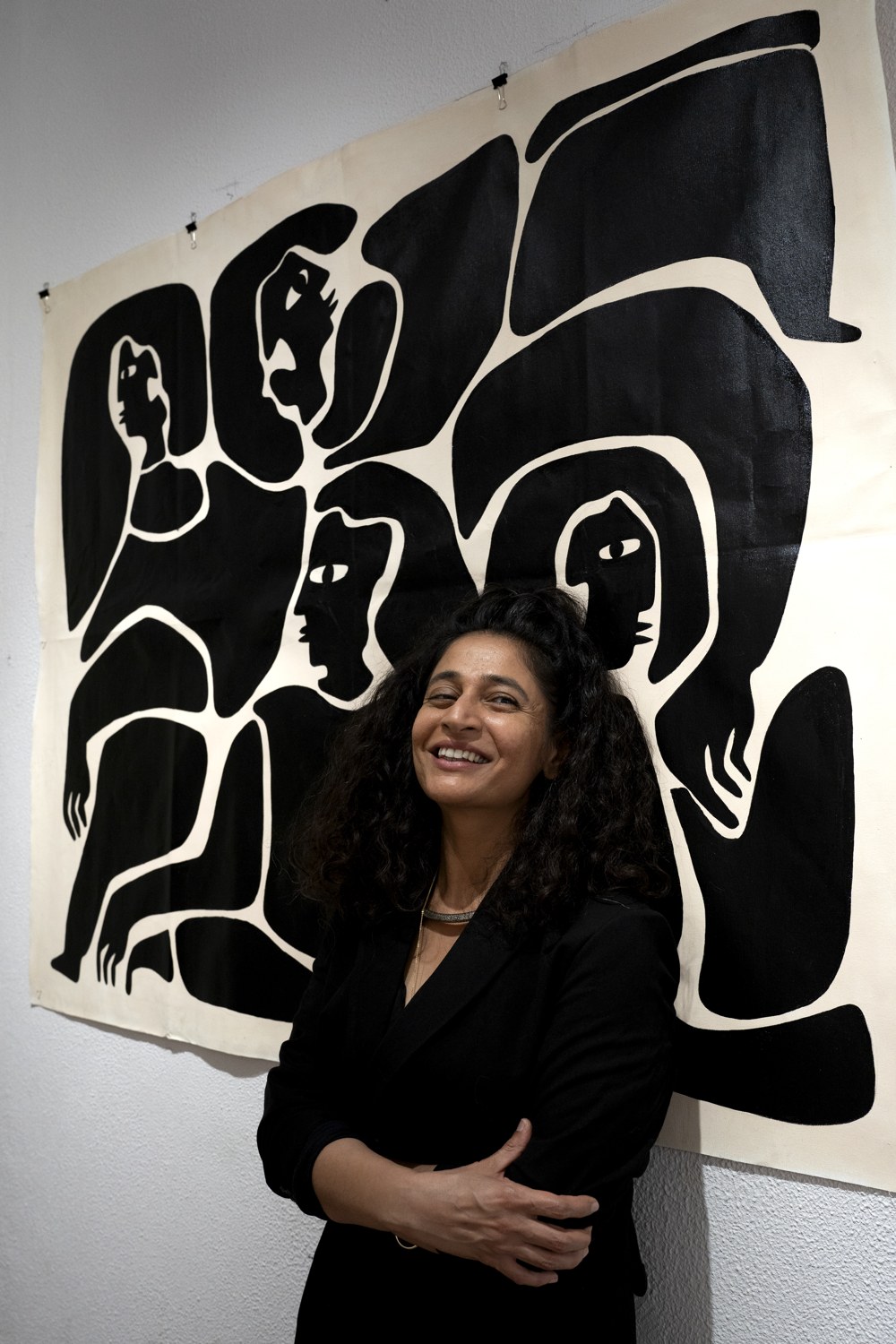 Neeta Khanuja in front of one of her large black-and-white figure paintings.