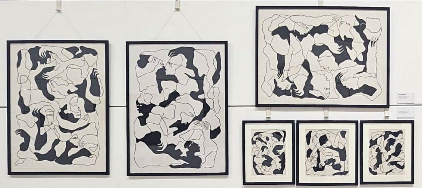 Seven framed drawings on a gallery wall.