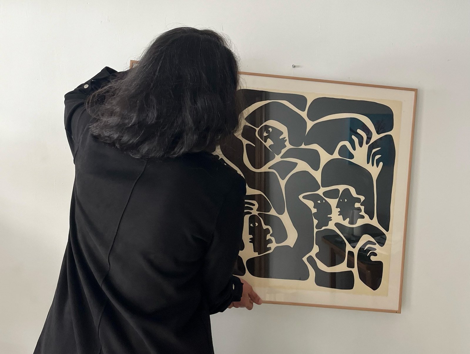 Hanging a framed black and white work on the gallery wall.