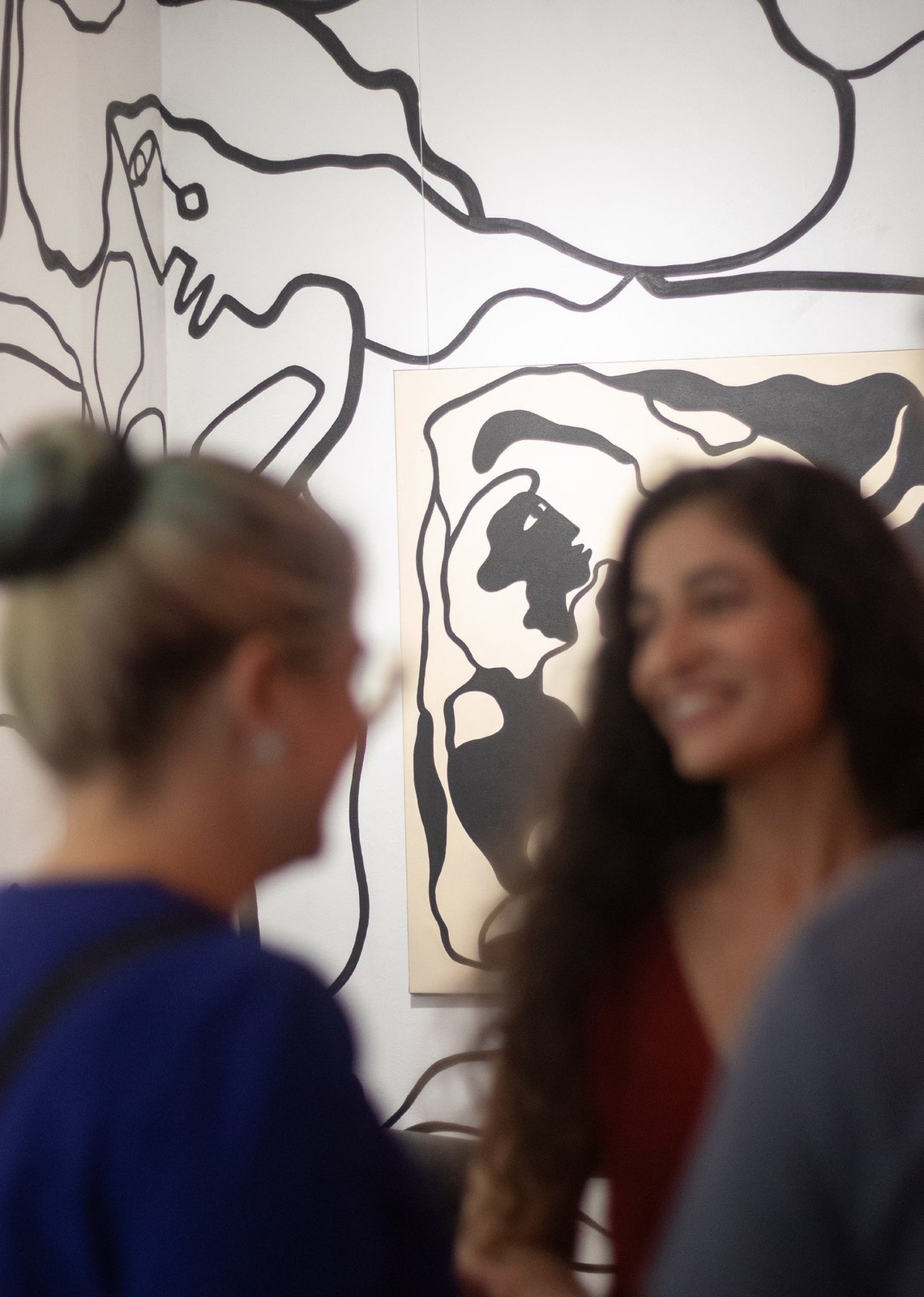 Visitors talking beside the wall drawing.