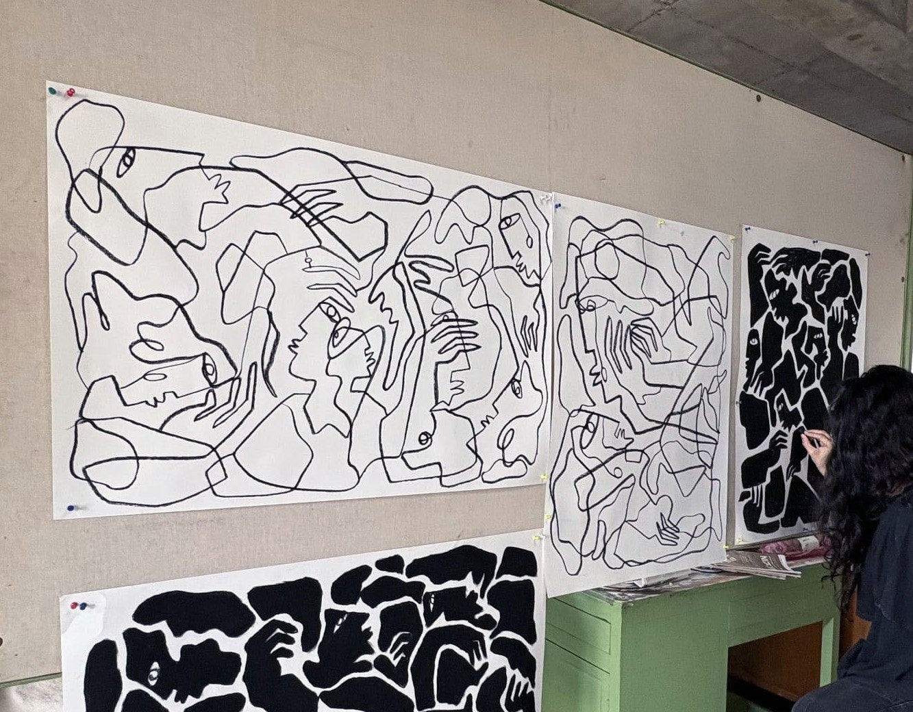 Long linocut prints and a charcoal drawing in the studio.