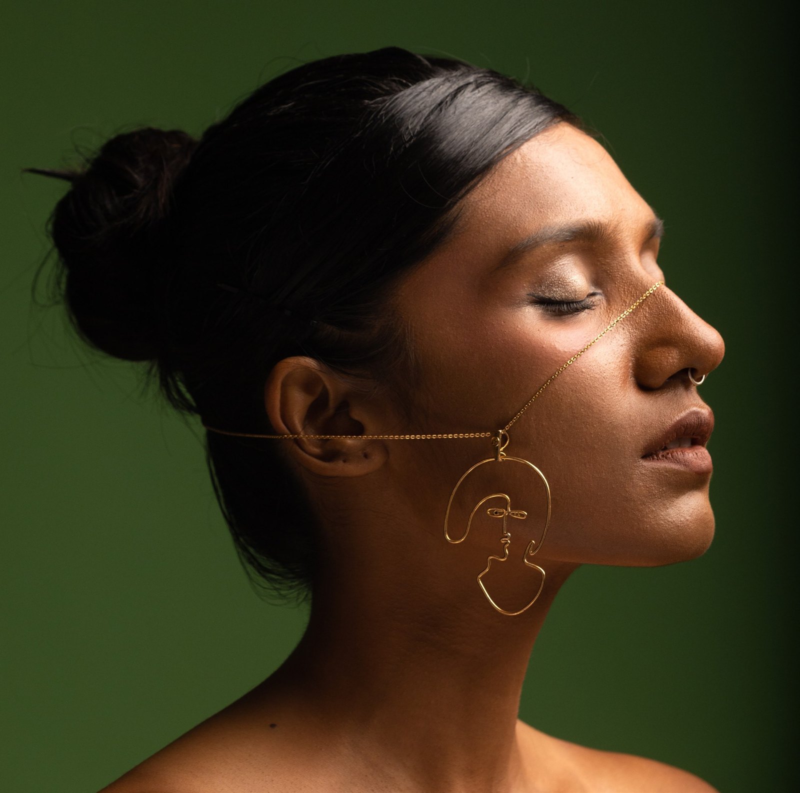 Dilemma: a brass earring in profile.