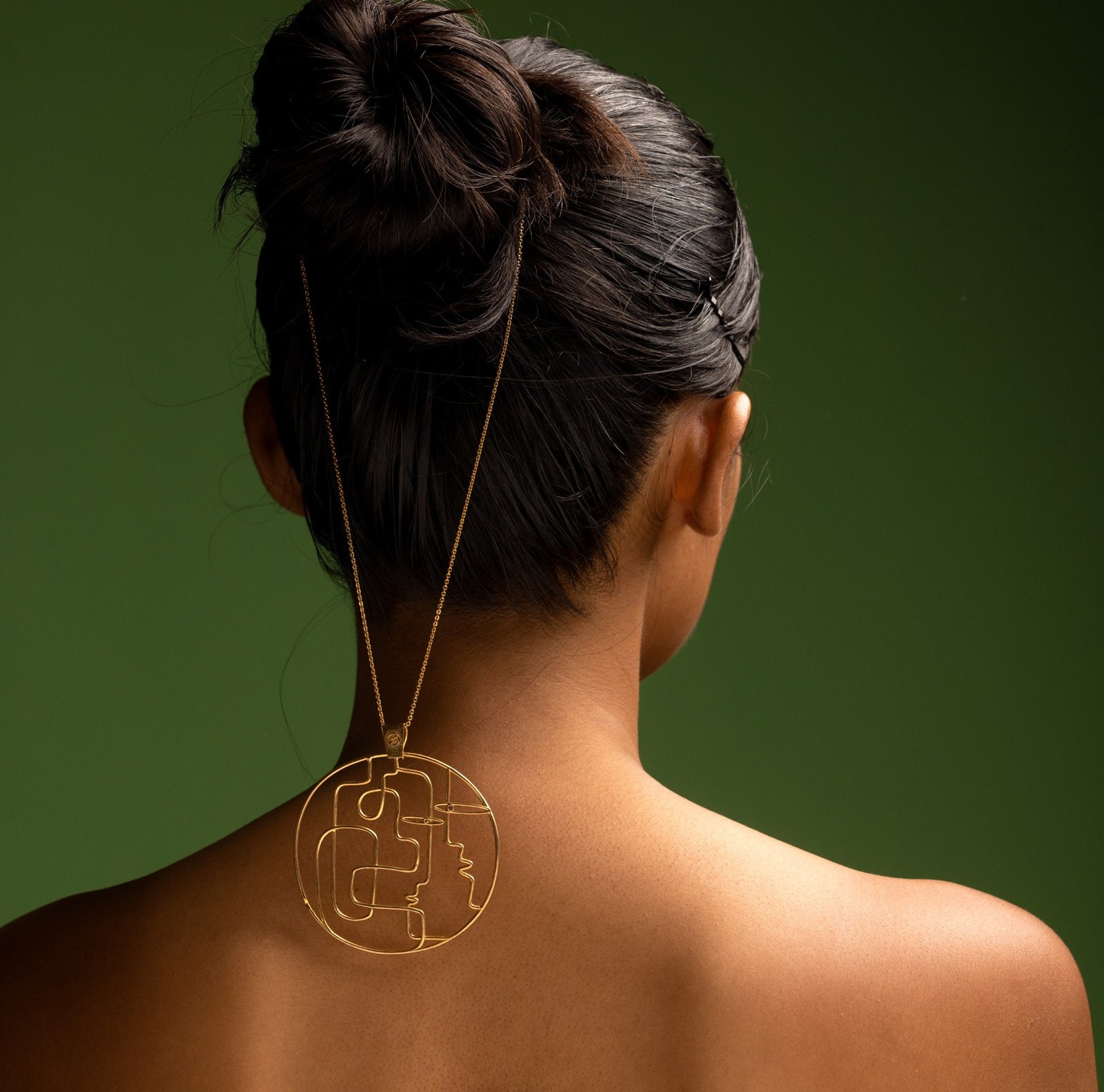 You and Me: a round pendant worn on the back.