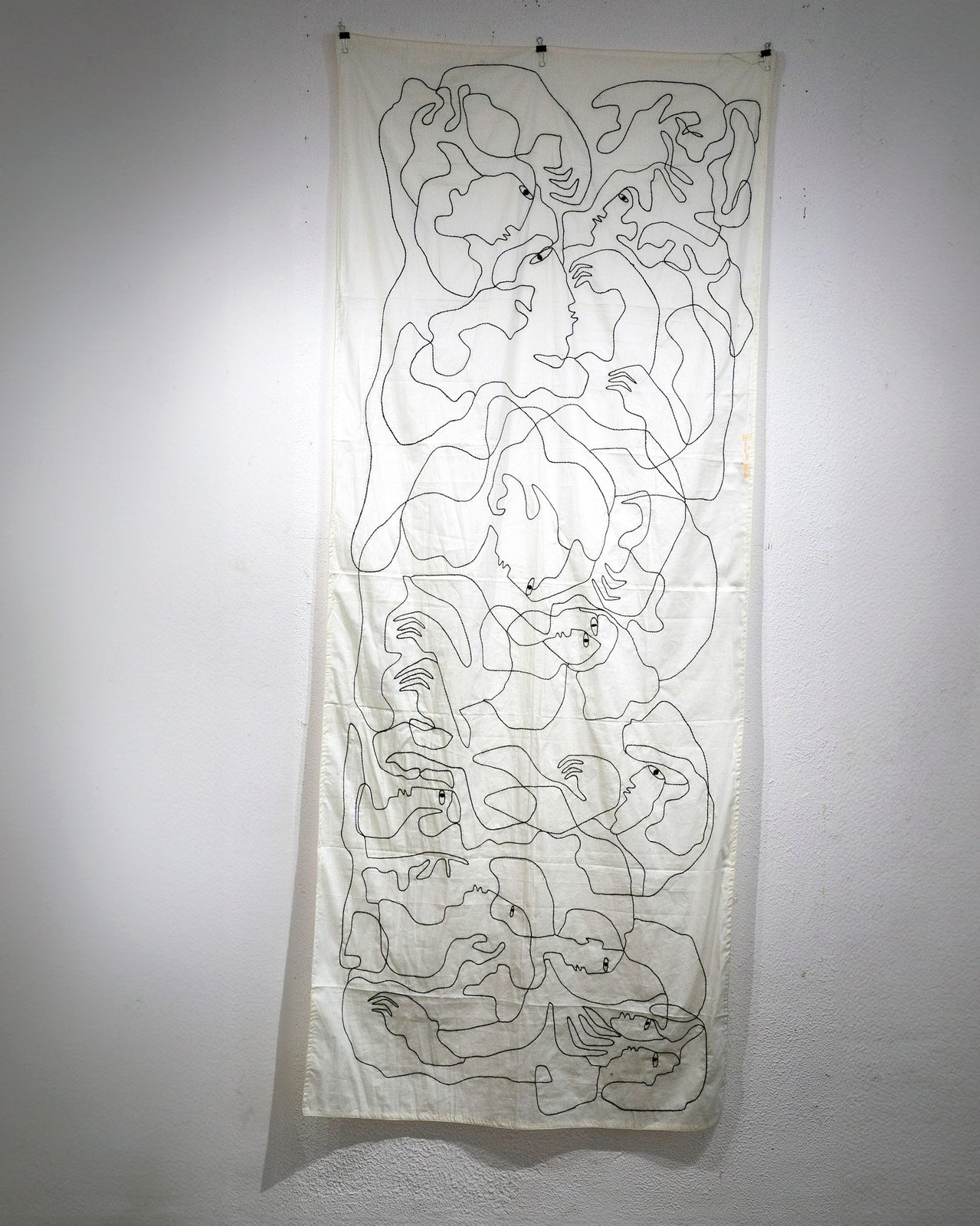 A tall embroidered textile hanging on a wall.
