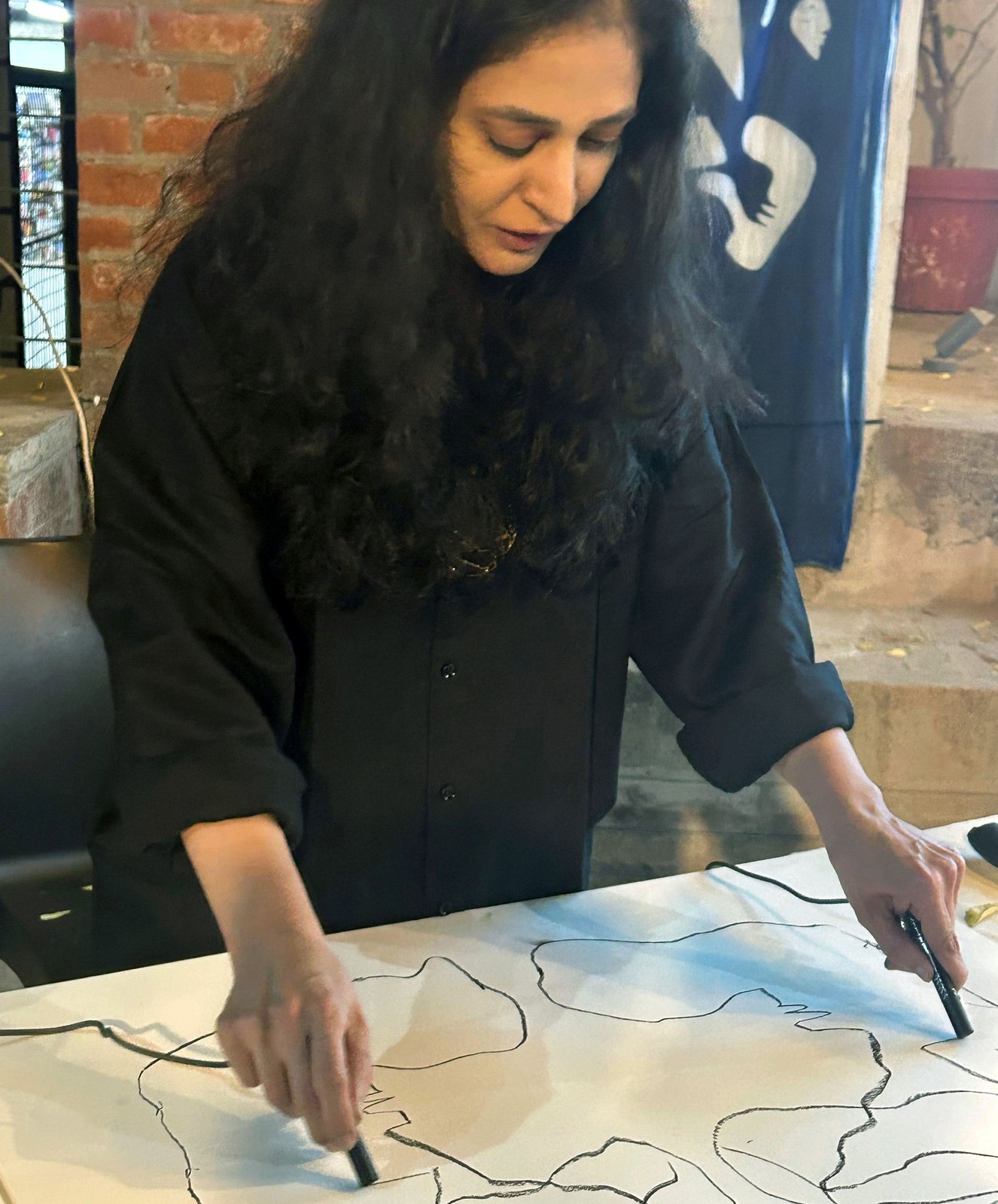 Drawing with both hands on a large sheet.