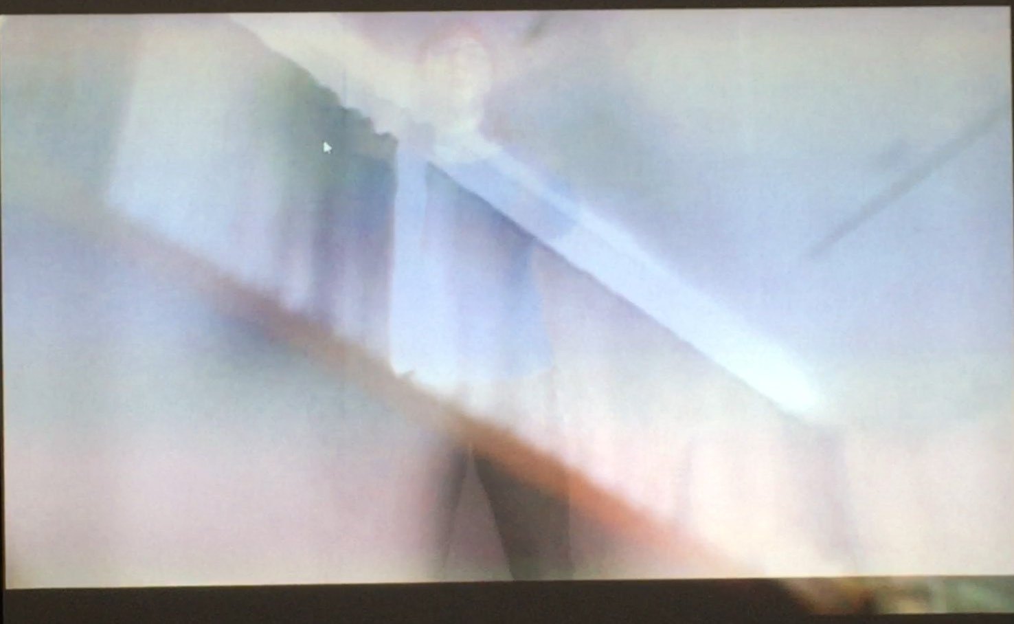 The projection after stillness: fog over the room, the figure almost gone.