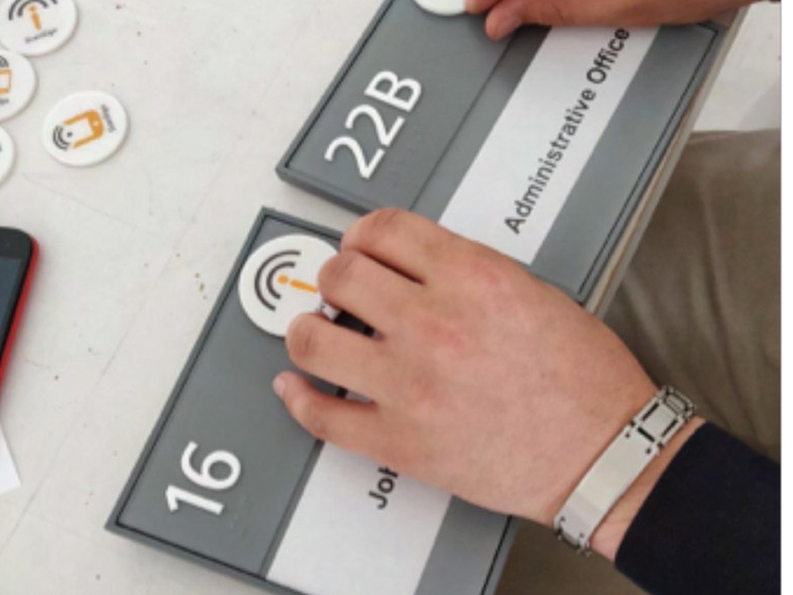 smart room signs cover: fingers finding a tactile tag on a room sign