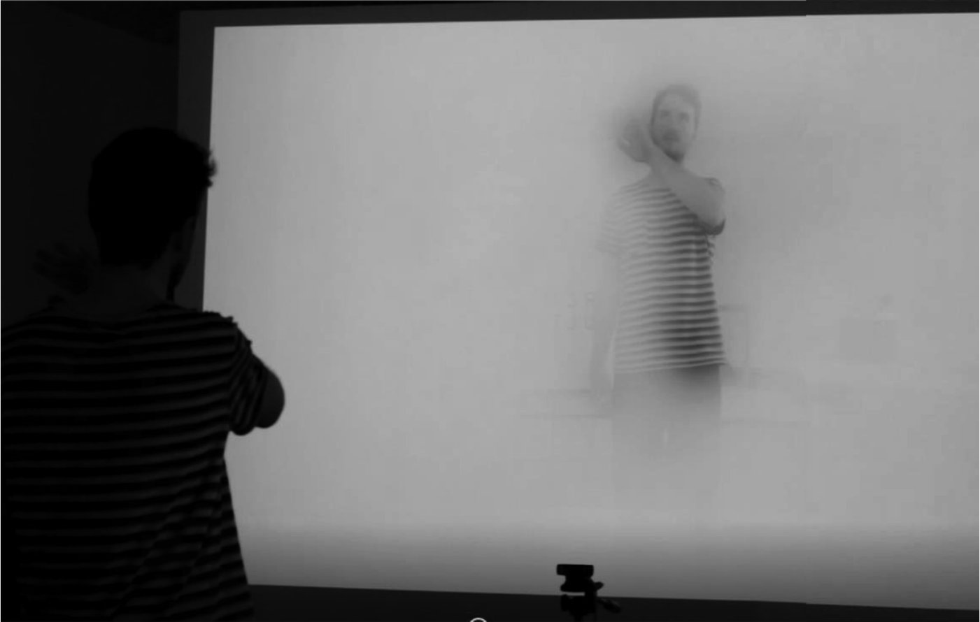 A colleague moves in front of the projection; their image shows through the fog.
