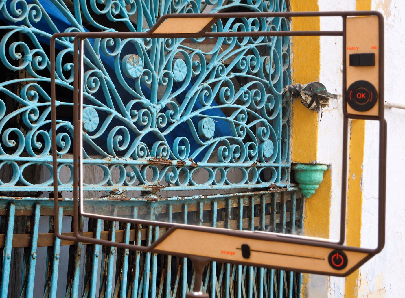 The frame held against a blue iron grille in the old city.