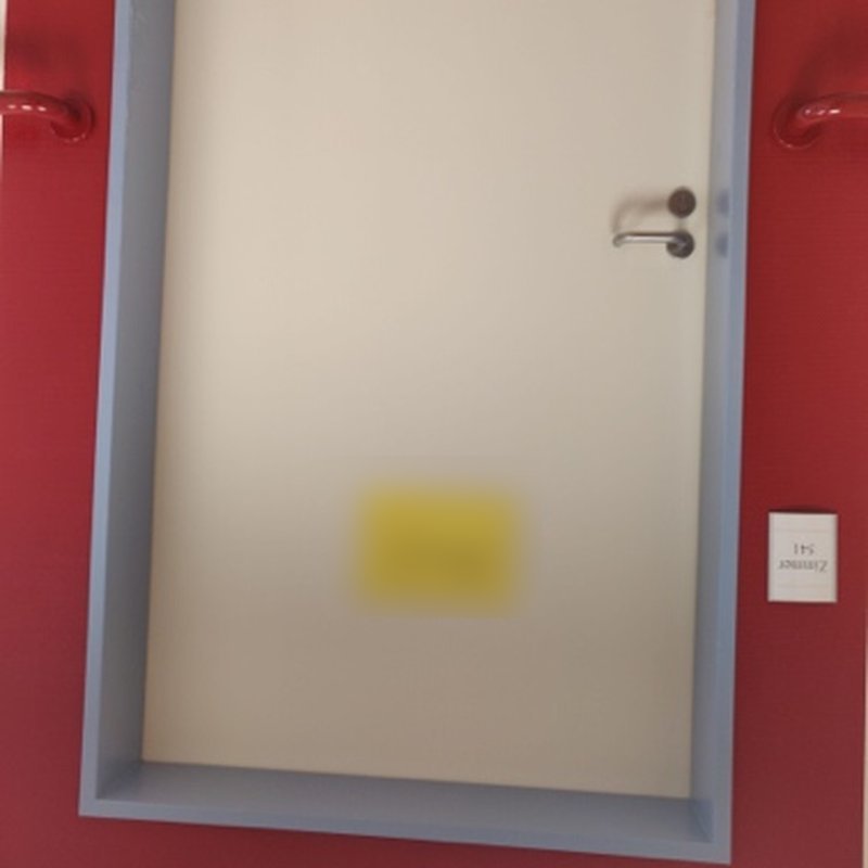 A door in a red frame on the same ward. Name card blurred.
