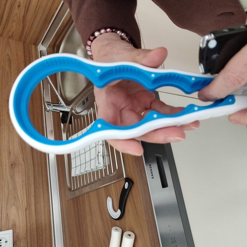 Hands holding a blue jar opener over a kitchen counter.