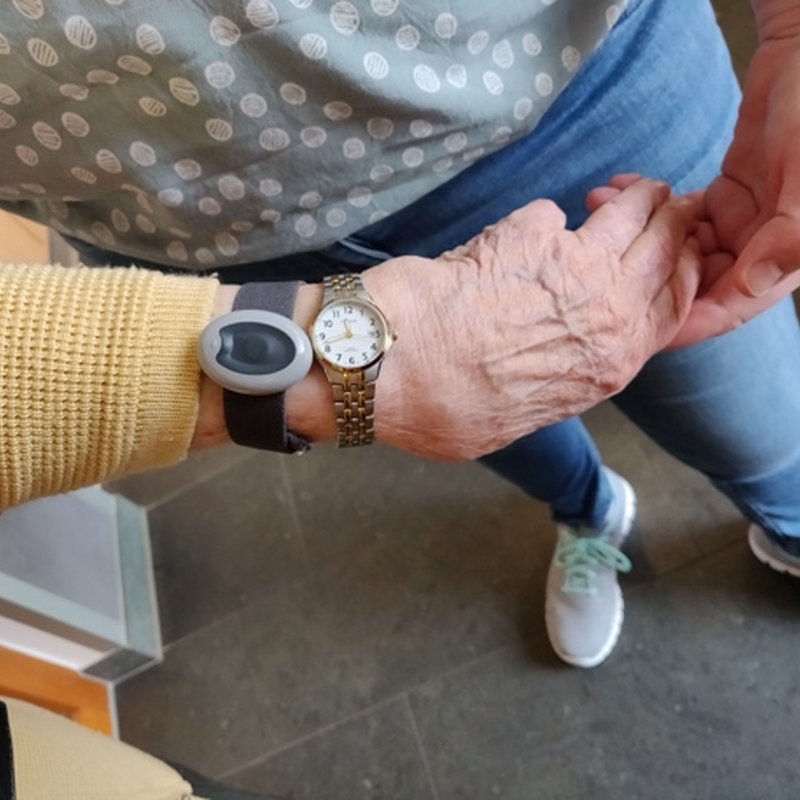 A wrist wearing two watches, a hand resting on it.